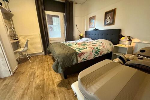 a bedroom with a bed and a chair in it at Cosy apartment in the centre of fortified town Groenlo in Groenlo