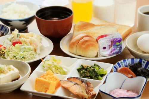 a table topped with plates of food and bowls of food at Hotel Pony Onsen in Towada