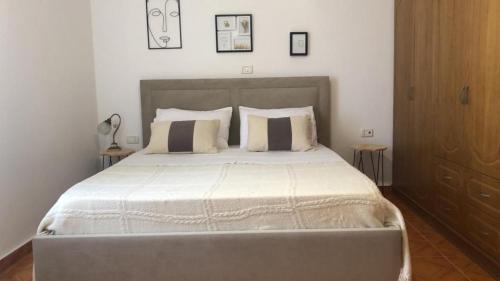 a bedroom with a large bed with white sheets and pillows at Blue Paradise Apartment in Lukovë