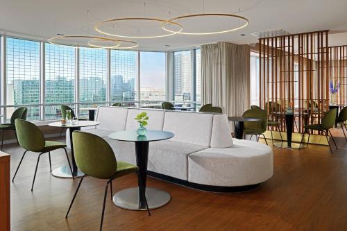 a living room with a couch and tables and chairs at Rotterdam Marriott Hotel in Rotterdam