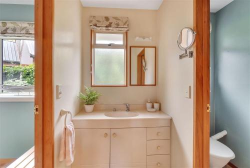 ein Bad mit einem Waschbecken und einem Spiegel in der Unterkunft Sweet Home in Christchurch