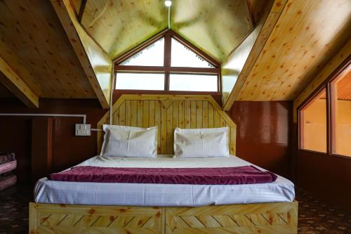 a bed in a room with a large window at JOYstels Kasol in Kasol