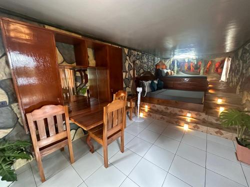 a room with a table and chairs and a bed at Gratum Beach Resort in Dapitan