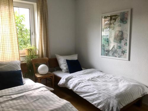 um quarto com 2 camas individuais e uma janela em Design+Bodenseesicht=zuHause BLAU em Markdorf