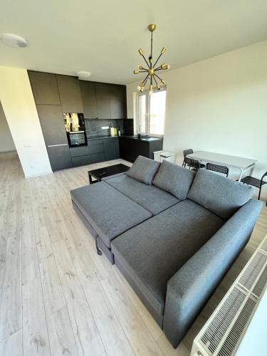 a living room with a couch and a kitchen at FREE 2X parking and free Wifi NEW Suncatcher apartment in Bratislava