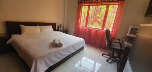 a bedroom with a bed with two shoes on it at Hilltop Greenview Residence Batu Caves Selayang in Batu Caves