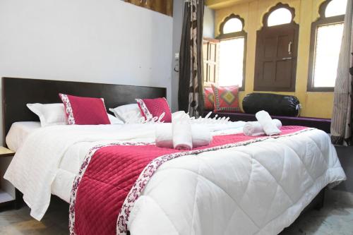 1 Schlafzimmer mit 2 Betten mit roten und weißen Decken in der Unterkunft Hotel Hashim in Jaisalmer