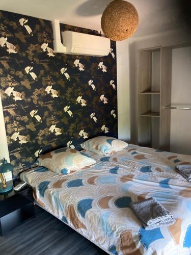 - une chambre avec un lit orné d'un mur fleuri dans l'établissement T3 sur fermette avec les animaux, à Lusigny