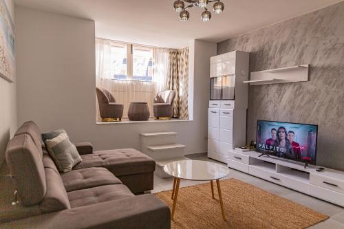 a living room with a couch and a tv at Fancy Modern APT Sliema - w/ 2BR in Sliema
