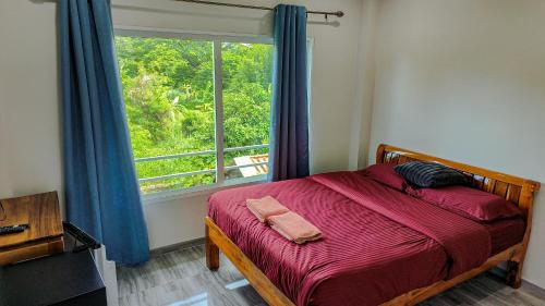 a bedroom with a bed with a large window at 99 House in Jomtien Beach