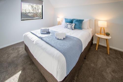 a bedroom with a large bed with two pillows on it at Sunsoaked & Stylish 3 Bed, 1.5 Bath Home w Garage in Christchurch
