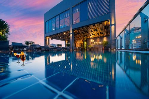 a building with a swimming pool in front of it at Northern Charm Hotel in Ho Chi Minh City