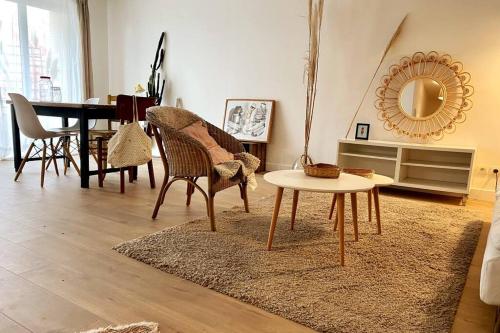 een woonkamer met een tafel en stoelen en een spiegel bij Beau 3 pièces cosy avec parking et terrasse in Bordeaux