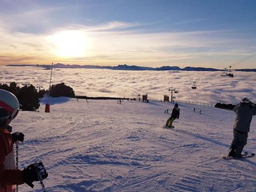 un groupe de personnes skier sur une piste enneigée dans l'établissement Belle maison au cœur des Alpes, à Le Pinot