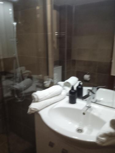 y baño con lavabo y ducha con toallas. en Golden village en Astakós