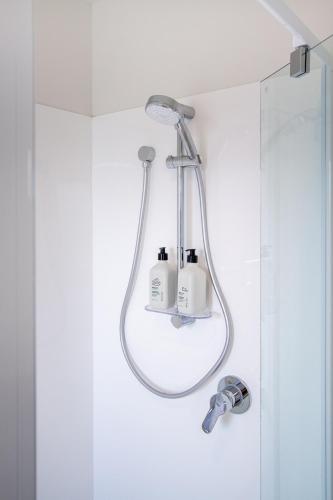 a shower with two soap bottles on it in a bathroom at Sunsoaked & Stylish 3 Bed, 1.5 Bath Home w Garage in Christchurch