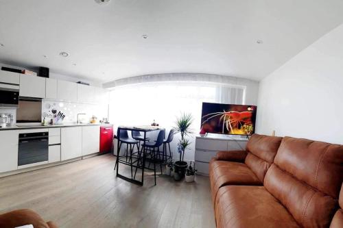 a living room with a couch and a kitchen at Luxury 1 bed apartment-sea view in Bournemouth