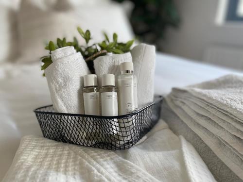 uma cesta cheia de toalhas e óleos essenciais numa cama em Quiet Luxe Home with GYM and Free Parking em Thamesmead