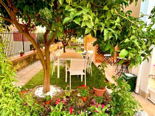una mesa y sillas bajo un árbol en un jardín en Dimora Leone, en Diamante