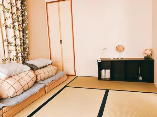a living room with a couch and a tv at Guest House SAKURA - Vacation STAY 57751v in Sakura