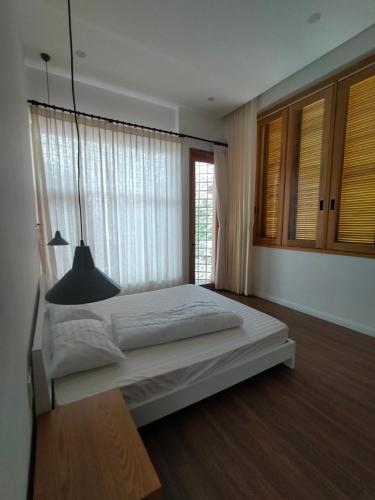 een slaapkamer met een groot bed en een raam bij Village Mai in Phan Thiet