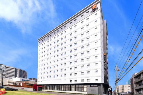 名古屋的住宿－Vessel Hotel Campana Nagoya，白色的建筑,旁边标有标志