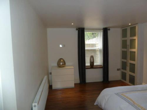 a white bedroom with a bed and a window at 2 Bed Apt close to City Centre in Sheffield