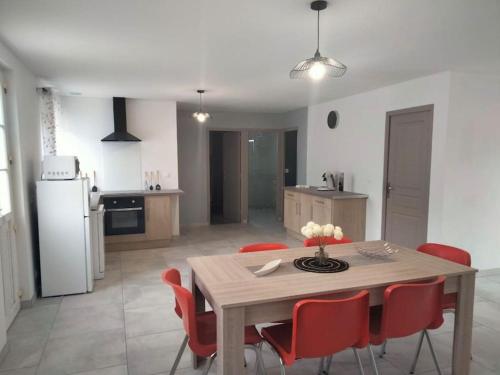 eine Küche und ein Esszimmer mit einem Tisch und roten Stühlen in der Unterkunft Jolie maison rénovée avec espace vert in Thonnance-lès-Joinville