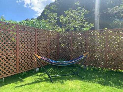 a hammock sitting in front of a fence at 一棟貸別荘 Oceanic Villa Minamiizu!17名まで!弓ヶ浜海水浴場まで徒歩6分 in Minamiizu