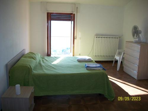 a bedroom with a green bed and a window at Sweet Home 2 in Montopoli in Sabina