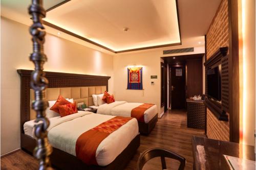 a hotel room with two beds and a television at Kantipur Village in Kathmandu