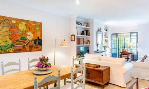 Apartamento Urbanización Benamara في إِستيبونا: غرفة معيشة مع أريكة بيضاء وطاولة