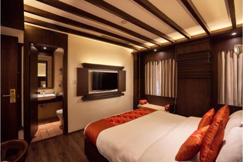 a hotel room with a large bed and a bathroom at Kantipur Village in Kathmandu