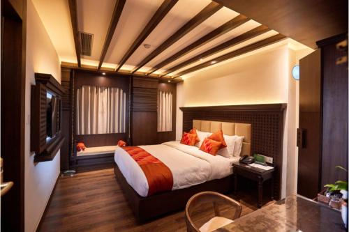 a bedroom with a large bed and a table and chair at Kantipur Village in Kathmandu