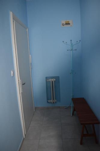 a blue room with a door and a wooden bench at Apartment Airport Sofia in Sofia