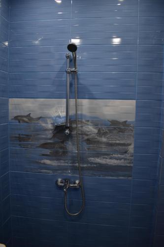 baño con ducha y pared de azulejos azules en Apartment Airport Sofia en Sofía