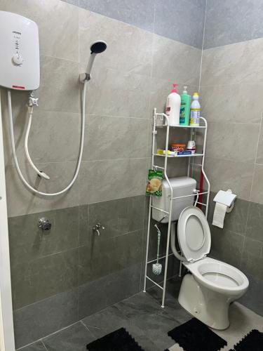 a bathroom with a shower with a toilet in it at Safiyya Homestay in Kota Bharu