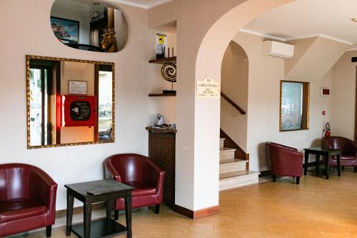 - une salle d'attente avec des chaises rouges et une machine dans l'établissement Rex Hotel Residence, à Gênes