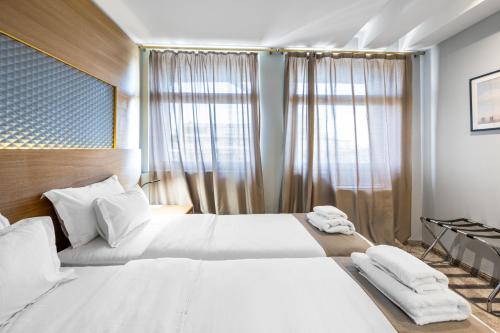 a hotel room with two beds with white sheets at Prince Rooftop in Belgrade