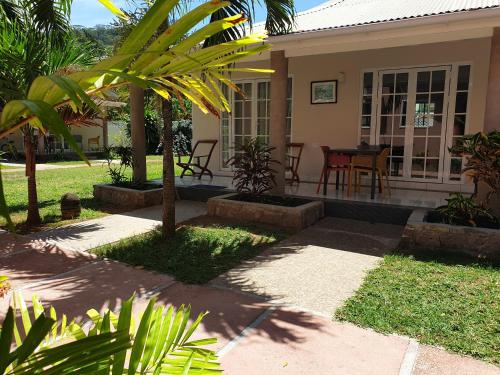 a house with a table and chairs in the yard at Villa Authentique in La Digue
