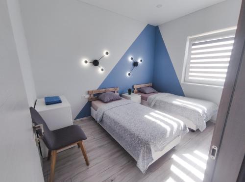 a bedroom with two beds and a blue wall at K-Town - Apartments ViaBaltic Kaunas in Kaunas