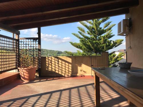 un patio con mesa y vistas a un árbol en Casa Vacanza I principini, en Paravati