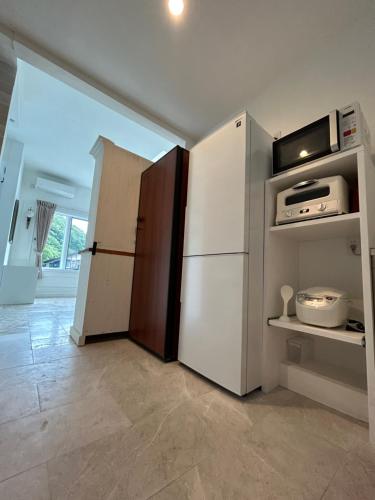 a kitchen with a refrigerator and a microwave at HAKONE DOMA in Hakone