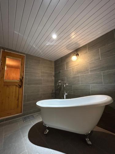 a large white bath tub in a bathroom at HAKONE DOMA in Hakone