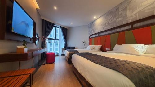 APEC MANDALA CHAM BAY MŨI NÉ في Ấp Thiẹn Ái: غرفة فندقية بسريرين وتلفزيون بشاشة مسطحة
