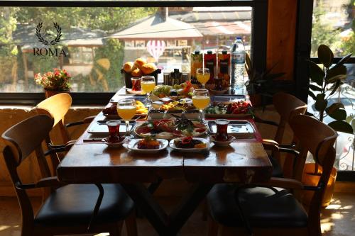 a wooden table with food and glasses of wine at Roma Cave Suite in Goreme