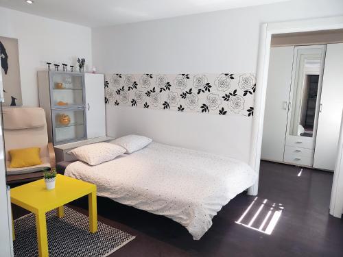 een slaapkamer met een bed en een gele tafel bij Zagreb Creative Apartments APP 2 in Zagreb