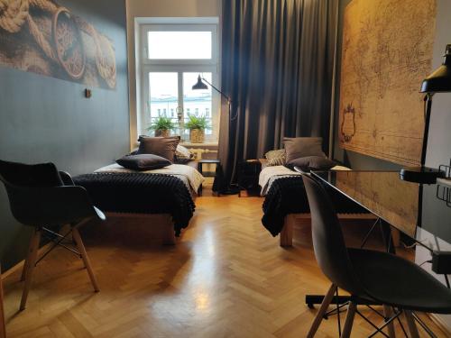 シュチェチンにあるSzarotkaのベッド2台、デスク、窓が備わる客室です。