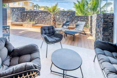 a patio with couches and chairs and tables at Villa standing 52 in Ravine des Cabris