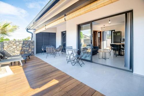 a living room and dining room with sliding glass doors at Villa standing 52 in Ravine des Cabris